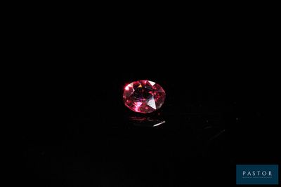 gros plan d'un diamant rose sur une surface noire