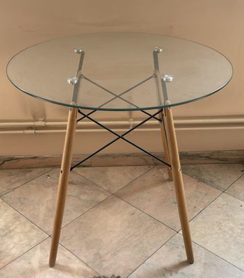 une table en verre avec des pieds en bois et un plateau en verre