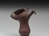 un vieux vase marron surmonté d'un oiseau