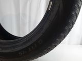 a close up of a tire on a white surface with a curtain in the background