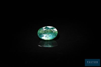 a green tourmaline gems on a black surface