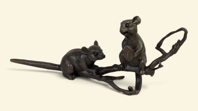 une figurine en bronze représentant une souris et un rat sur une branche