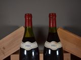 pair of bottles of wine sitting on top of a wooden crate