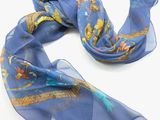 une écharpe bleue ornée d'un motif représentant un oiseau et des fleurs