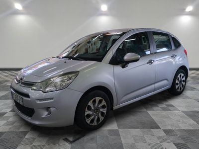 la petite voiture argentée est garée sur un sol en damier