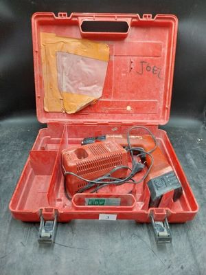 une vieille boîte à outils rouge contenant une perceuse filaire et d'autres outils