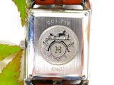 a silver watch with a brown leather strap on it