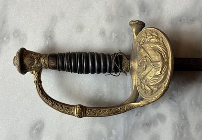 an old sword with a gold handle on a white surface