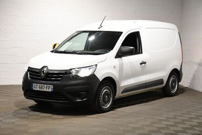 La camionnette blanche est garée dans une grande pièce au sol carrelé en damier.