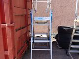 a ladder that is sitting next to a red dumpster