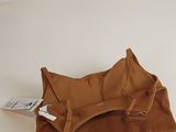 the small brown bag is sitting on the table next to a white wall