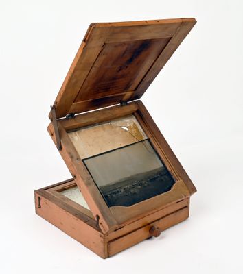 a small wooden box with a mirror inside of it
