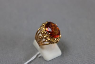 Gros plan sur une bague en or ornée d'une pierre rouge