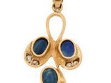 a close up of a gold pendant with blue stones
