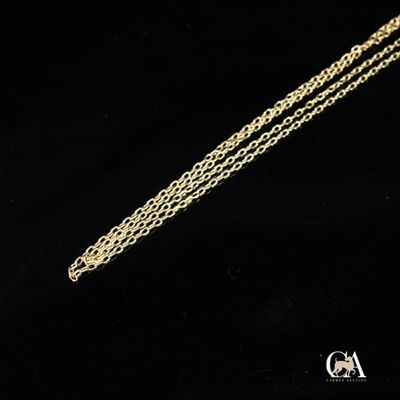 un gros plan d'un collier en or avec une chaîne sur fond noir