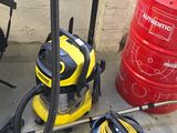 yellow and black vacuum cleaner sitting on the ground next to a red barrel