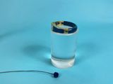 a glass of water with a gold ring on top of it