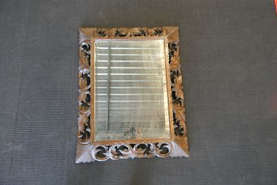un miroir posé sur le sol à côté d'une chaise