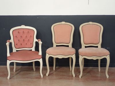 Dans une pièce, trois chaises sont alignées contre un mur noir