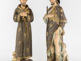 two statues of a man and a woman with a dog