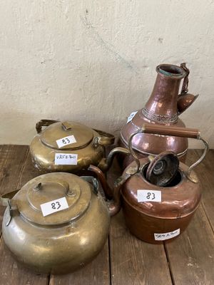 trois casseroles et une bouilloire posées sur un plancher en bois