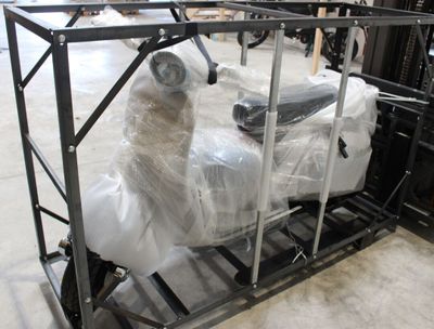 un scooter emballé dans du plastique et posé sur une palette