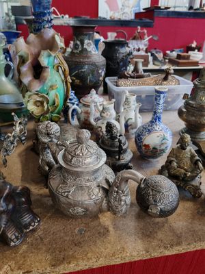 de nombreux vases différents sur la table de cette pièce