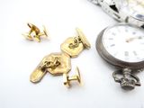 a pocket watch, cuff watches, and other jewelry on a table
