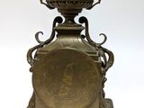 a metal clock that is sitting on top of a table