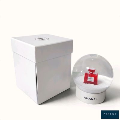une petite boule à neige avec une boîte rouge et une boîte blanche