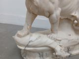 a statue of a dog that is standing on a rock
