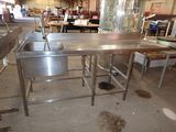 une table de cuisine avec un évier et un plan de travail au milieu de la pièce
