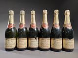 six bouteilles de champagne sont alignées