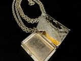 silver and gold locke with a chain on a black background