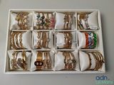 une boîte blanche remplie d'une multitude de bracelets en or et en argent