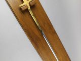 a wooden plaque with a sword on it on the wall