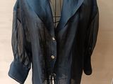 jacket on a mannequin stand in front of a wooden wall