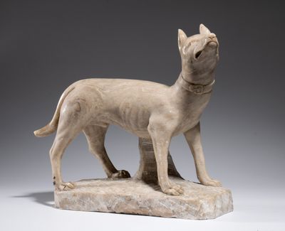 statue of a dog standing on a rock on a gray background