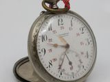 a silver pocket watch with a red string on it