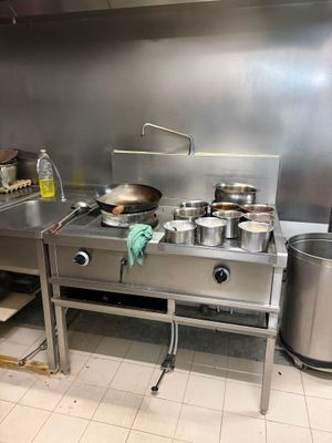 une cuisine avec une cuisinière et une casserole posée sur le plan de travail