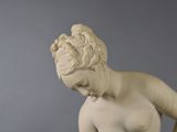 a statue of a woman holding a vase with a flower in it