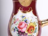 an image of a red and gold teapot with flowers on it