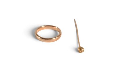 a gold ring and a stick on a white surface