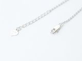 a close up of a silver chain with a heart on it