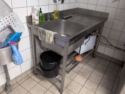 a stainless steel sink in the corner of a kitchen