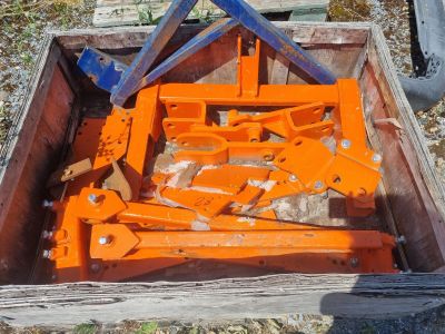 une caisse en bois posée par terre, remplie de matériel de chantier de couleur orange