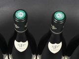 six bottles of wine are lined up in a row on a table