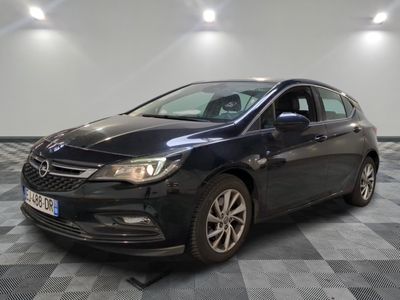 a black car is parked in a room with a checkered floor