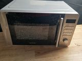 a microwave sitting on a wooden table with a black background