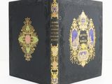 un vieux livre noir aux bords dorés et à la couverture décorative